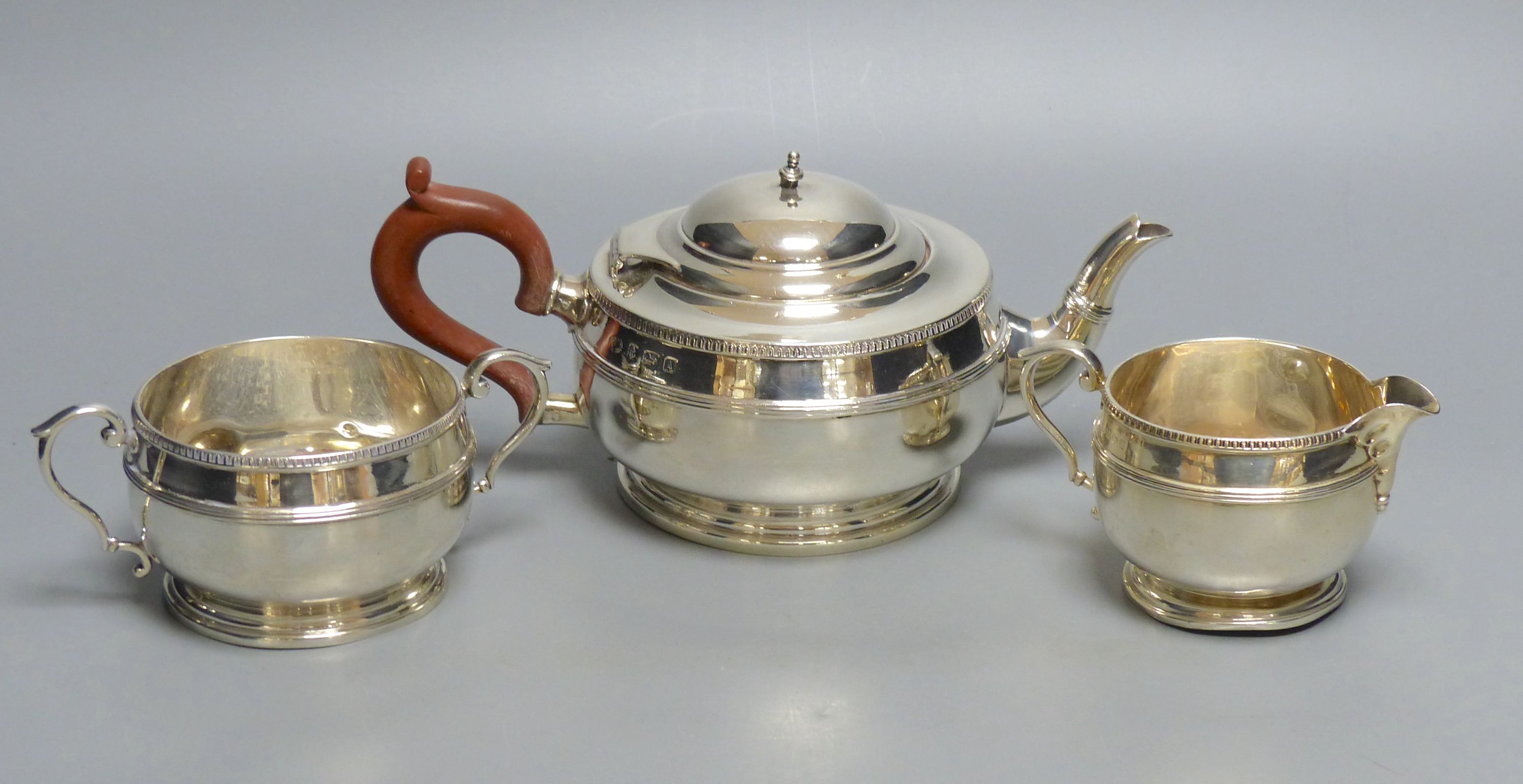 A matched silver three-piece tea service of squat reeded circular form, gross 28.25oz